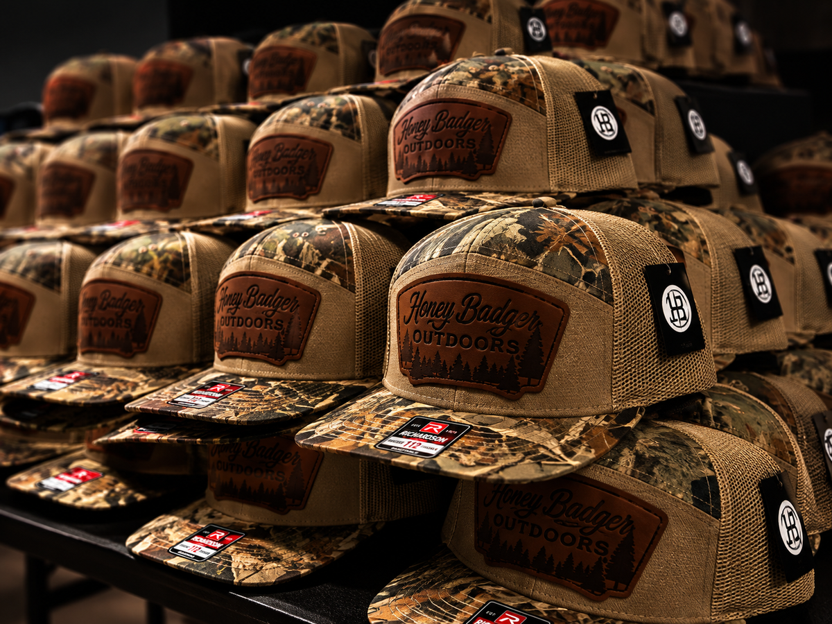 Honey Badger Outdoors custom patch hats arranged in a dramatic product display by Vaultline Branding