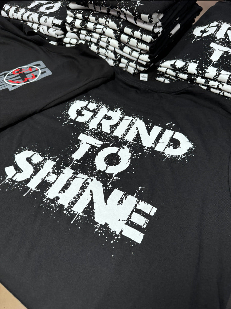 Large Grind To Shine white screen print on black apparel